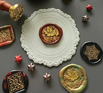Sealing stamp and wax seals on table.