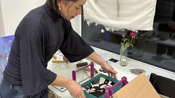 Frau bastelt mit Papier im Workshop.