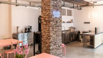 Küchenstudio mit Backsteinpfeiler, moderne Möbel.