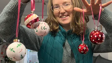 Frau hält bunte Kugeln drinnen