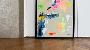 Abstraktes Gemälde lehnt auf Holzboden.