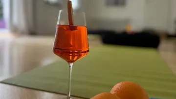 Orangengetränk im Glas auf Tisch.