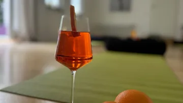 Glass with orange drink on table.