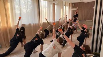 Personen machen Yoga mit Getränken drinnen.