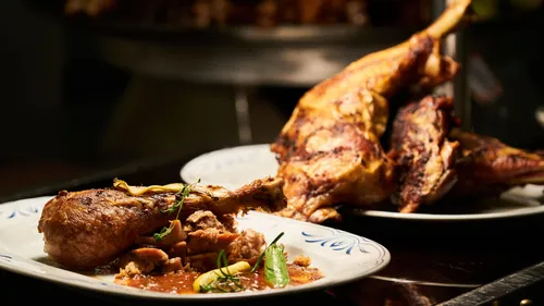 Cooked chicken pieces on white plates.