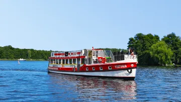 Rotes Ausflugsboot fährt auf einem See.