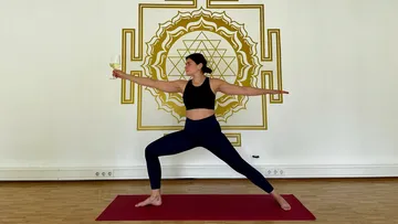 Frau macht Yoga-Pose mit Weinglas.