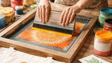 Hände bedrucken buntes Motiv mit Siebdruck