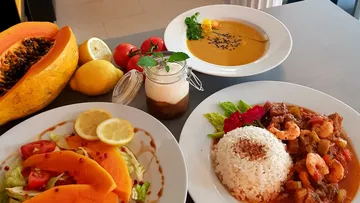 Verschiedene Gerichte mit Papaya und Reis auf Tisch.