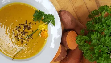 Kürbissuppe mit Kräutern und Samen garniert.