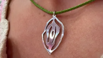 Silberanhänger an grünem Halsband.