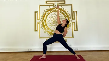 Person doing yoga pose with a drink.