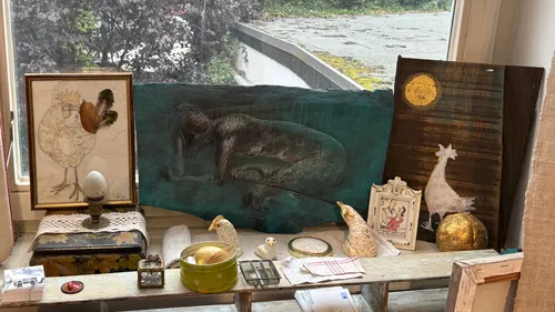 Art display with paintings on windowsill.