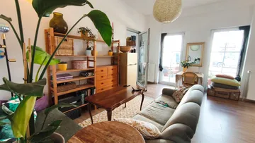 Wohnzimmer mit Sofa und Pflanzen.