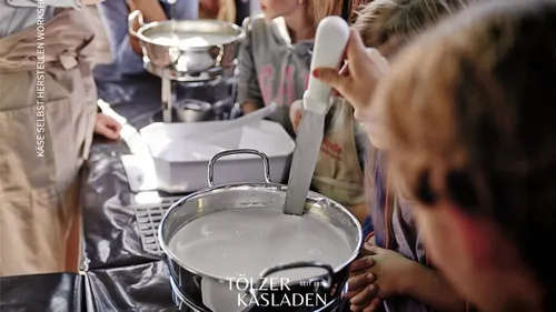 Kinder rühren Milch im Käseherstellungskurs.