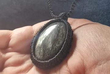 Stone pendant held in a hand.