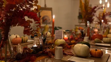 Pumpkins and candles on decorated table.