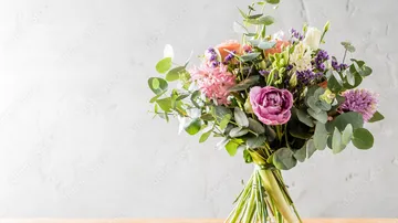 Flower bouquet in vase on wooden table.