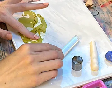 Hände modellieren mit Polymerton auf Tisch.