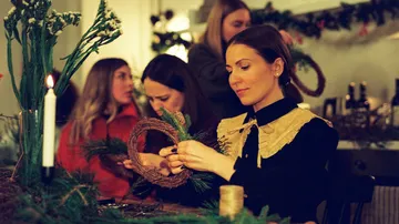Women making wreaths at a festive workshop.