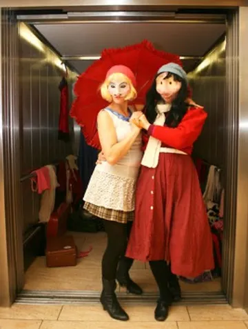 Two people in costumes inside an elevator.