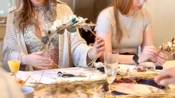 Women crafting wreaths in a cozy kitchen.