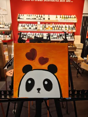 Panda painting with hearts, displayed in wine shop.