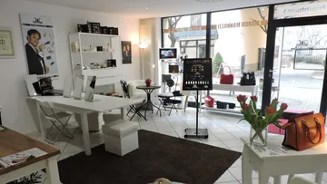Makeup studio with tables and cosmetics displays.