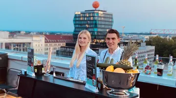 Zwei Barkeeper bedienen auf Dachterrassenbar.