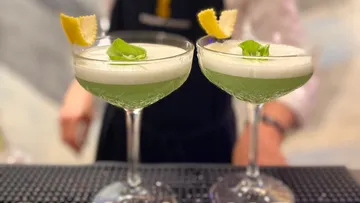 Zwei Cocktails mit grünem Schaumgarnitur.