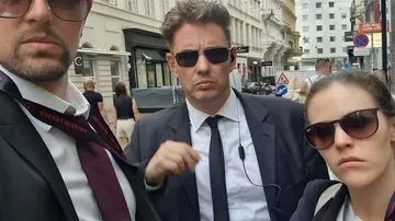 Three people with sunglasses standing on street