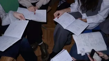 People studying with notebooks on floor.