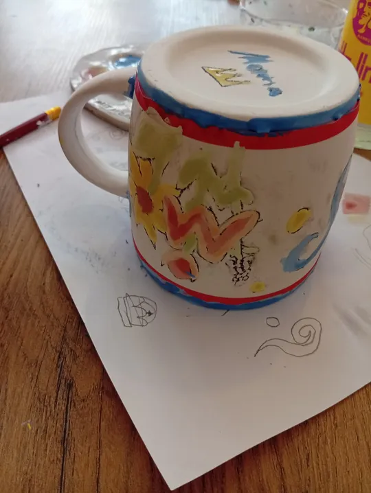 Mug with abstract art on paper sheet.