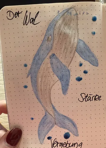 Whale drawing on dotted notebook page.