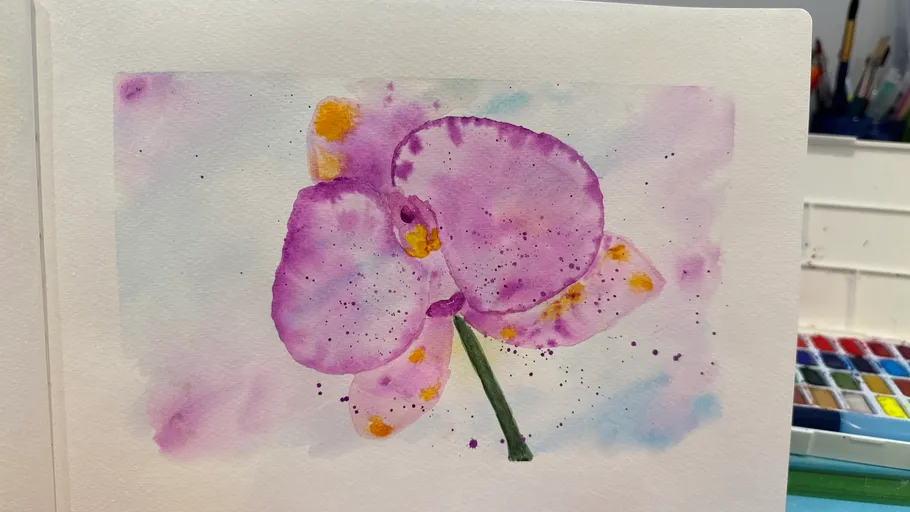 Purple orchid watercolor in artist's studio.