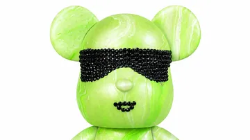 Grüne Bärenfigur mit Perlenmaske.