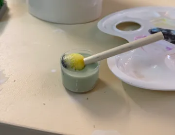 Schaumpinsel im Farbbehälter, Palette daneben.