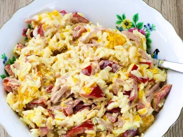 Reissalat mit Schinken und Gemüse in einer Schüssel.