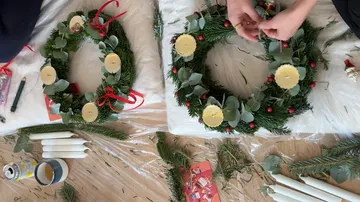 Zwei Weihnachtskränze werden auf einem Tisch gemacht.