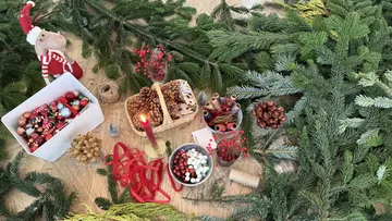 Weihnachtsschmuck auf Tisch mit Tannenzweigen.