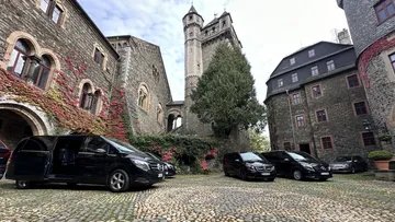 Schwarze Vans im Schlosshof geparkt.