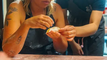 Hände machen Knödel auf einem Tisch.