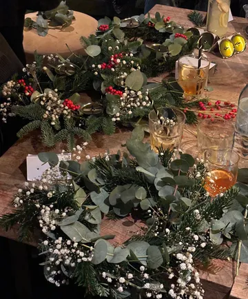 Weihnachtskränze auf Holztisch arrangiert.