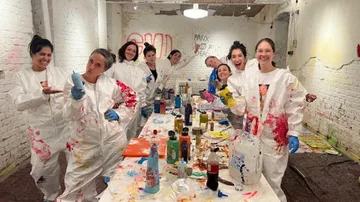 Group painting wearing white suits indoors.