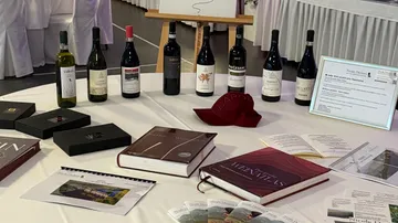 Table with wine bottles and brochures displayed.