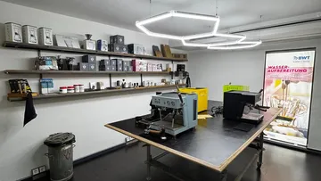 Kaffeemaschinen auf Tisch in modernem Laden.
