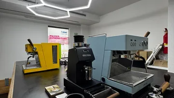 Drei Espressomaschinen auf einer Küchenzeile.
