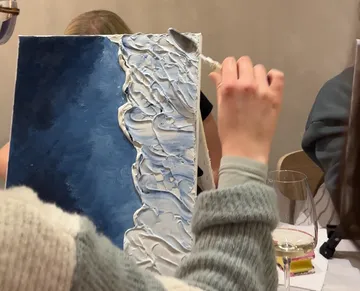 Person malt strukturiertes Leinwand mit Spachtel.