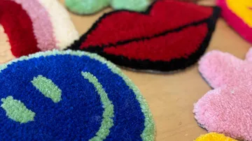 Colorful tufted shapes on wooden surface.