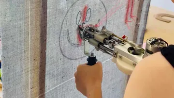 Roboterarm zeichnet auf Leinwandfläche.